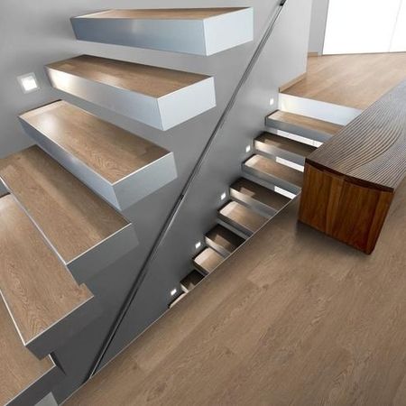Moderne Treppe mit Holzstufen und eleganten Metallakzenten auf hellem Boden