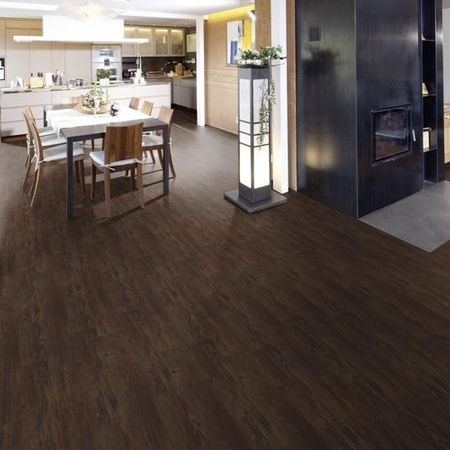 Küche und Essbereich mit dunklem Holzboden, minimalistischer Beleuchtung und schlichtem Mobiliar