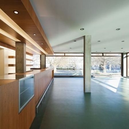 Modernes Interieur mit Holzakzenten, großen Fenstern, die natürliches Licht hereinlassen