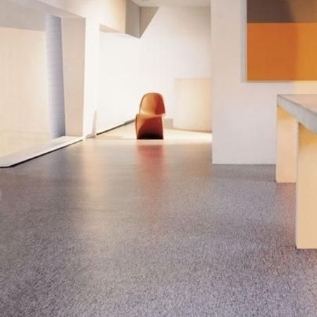 Ein minimalistischer Innenraum mit einem einzelnen braunen Stuhl, sanfter Beleuchtung und geometrischen Farbblöcken an der Wand