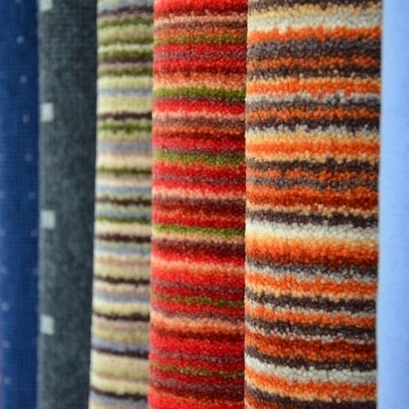 Eine Reihe von farbenfrohen Stoffmustern mit verschiedenen Mustern und Texturen, darunter Streifen und Unifarben