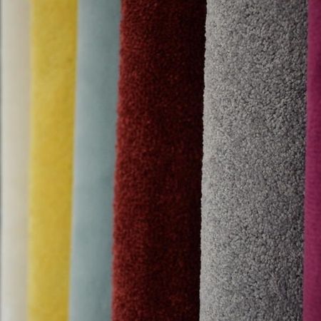 Eine Reihe Stoffmustern in verschiedenen Farben, darunter grün, gelb, rot, grau und lila